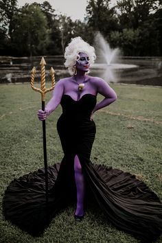 a woman dressed in black and purple poses for a photo while holding a sception