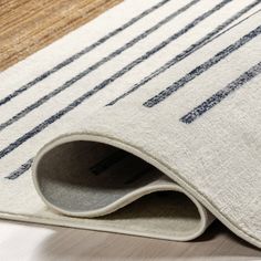 a close up of a rug on the floor with a white and blue stripe pattern