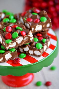 there is a green and white plate with some candy bars on it that are stacked high in the air