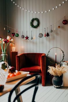 a living room filled with furniture and christmas decorations on the wall next to a table