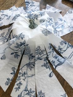 several pieces of paper with blue and white designs on them sitting on a wooden floor