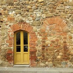 an old brick building with a yellow door and window stock photo - 957982