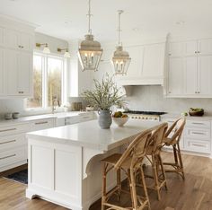 a kitchen filled with lots of white cabinets and counter top next to a dining room table