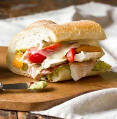 a cut in half sandwich sitting on top of a cutting board next to a knife