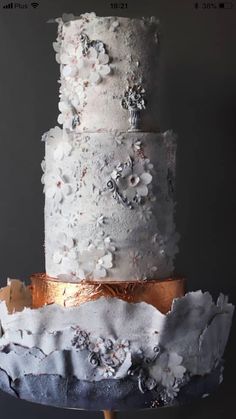 a three tiered cake with white frosting and flowers on it