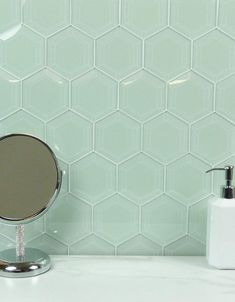 a bathroom counter with a mirror and soap dispenser