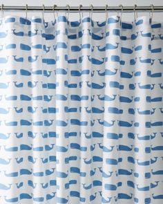 a blue and white shower curtain with whales on it