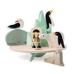 an animal figurine is sitting on top of a wooden table with penguins and birds