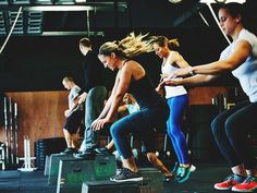 a group of people doing squats in a gym