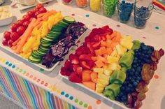 a table filled with lots of different types of fruits and vegetables on it's trays