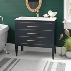 a white bath tub sitting next to a bathroom sink under a mirror and a wooden vanity