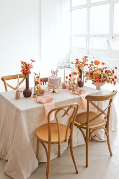 the table is set with flowers and cake