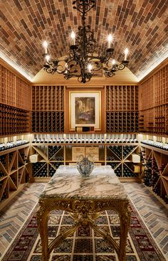 a wine cellar with several rows of bottles and a chandelier hanging from the ceiling