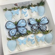 some blue butterflies and strawberries in a box