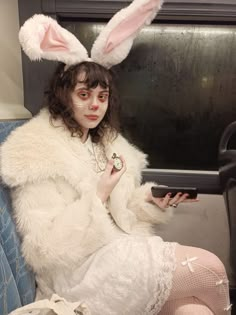 a woman in bunny ears sitting on a couch