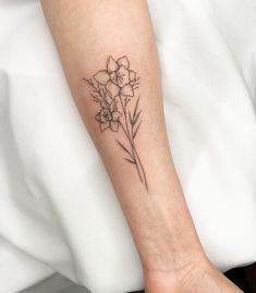 a woman's arm with a flower tattoo on the left side of her wrist