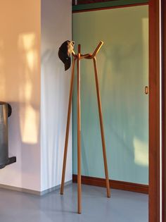 a coat rack with a hat on it next to a door