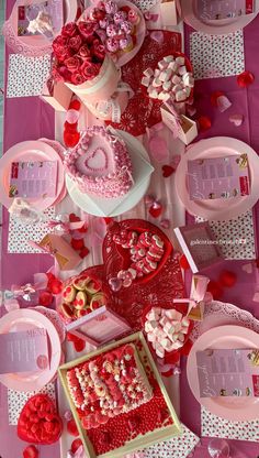 valentine's day table setting with heart shaped cakes and desserts on pink plates