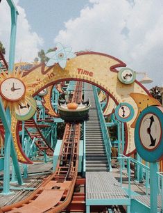 an amusement park ride that is going down the hill with clocks on it's sides