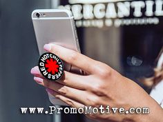 a person holding a cell phone with a red hot chili logo on the front and side