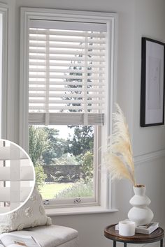 a living room filled with furniture and windows covered in white shutters, next to a coffee table