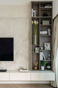 a flat screen tv sitting on top of a wooden shelf