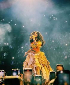 a woman standing on top of a stage in front of a large group of people