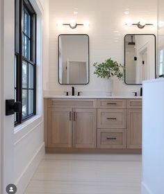 a bathroom with double sinks and mirrors on the wall