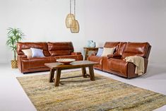 a living room with two couches and a coffee table on top of a rug