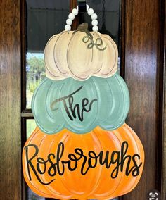 a door hanger that says, the rolobroughs and three pumpkins