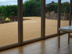 an empty room with sliding glass doors and hard wood flooring on the outside wall