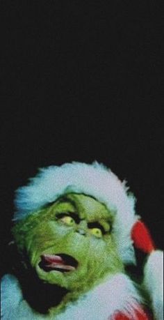 the grinch is wearing a santa hat and holding his hand up to his ear