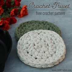 two crochet coasters sitting next to each other on the ground with flowers in the background