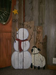 a snowman and a sheep painted on wooden boards with words do you see what?