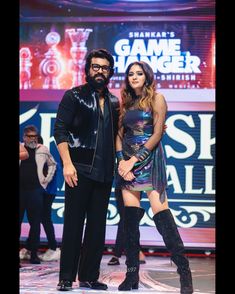 a man and woman standing on stage in front of a game changer sign