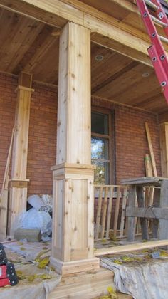 a red ladder is on the front porch of a house with wood siding and windows