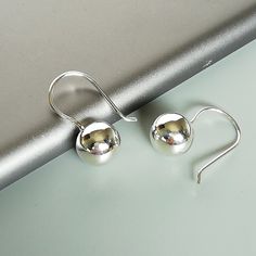 A PAIR of sterling silver ball danglers. These earrings are made of 925 hypoallergenic sterling silver. Size: 10 mm Drop length: 21 mm Weight: 2.5 gm All my pieces are sent in a gift box. I can include a personal message from you if needed. You are welcome to contact me at... bhavnakwintra1956@gmail.com More hoops: https://www.etsy.com/your/shops/TheSilverGame/tools/listings/section:26305414 More earrings: https://www.etsy.com/your/shops/TheSilverGame/tools/listings/section:26308789 Ear climbers Silver Dainty Earrings Simple Design, Dainty Silver Earrings With Simple Design, Simple Sterling Silver Earrings As Gift, Sterling Silver Simple Design Earrings For Gift, Classic Sterling Silver Earrings With Simple Design, Dainty Sterling Silver Earrings With Simple Design, Simple Silver Round Earrings, Silver Earrings With Simple Design For Everyday, Simple Design Silver Earrings For Everyday