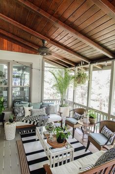 an outdoor living room with lots of furniture and plants on the table in front of it