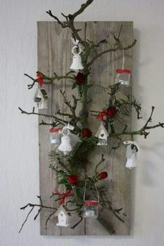 a tree with ornaments hanging from it's branches on a wooden wall mounted plaque