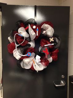 a black door with red and white flowers on it in a bathroom stall next to a toilet paper dispenser