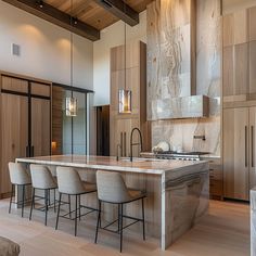 a large kitchen with an island in the middle and lots of chairs at the counter