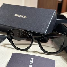 Rarely Worn. Like New. All Case, Box, Clothes Are Include. Product Details Acetate Sunglasses From The Prada Symbole Collection. The Bold Frame Is Characterized By The Geometric Design With The Feminine Cat-Eye Shape. The Frame Front Has Faceted Rims Combined With Three-Dimensional Temples Decorated With An Iconographic Interpretation Of The Traditional Prada Triangle Logo. Product Code: Pr07ysf Acetate Frame Front In Black Frame Compatible With Graduated Lenses 100% Uva / Uvb Protection Standar Designer Acetate Sunglasses For Formal Occasions, Designer Acetate Sunglasses For Formal Wear, Womens Prada Sunglasses, Box Clothes, Sunglasses Prada Women, Prada Square Sunglasses, Prada Shield Sunglasses, Prada Triangle, Logo Sunglasses