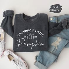 Searching for a fun, unique, minimalist sweatshirt that will express your overwhelming excitement for a new baby? Look no further than our "Growing a Little Pumpkin Gildan sweatshirt"!   This flattering top will get lots of compliments from your friends and family!  Ideal for any situation, a unisex heavy blend crewneck sweatshirt is pure comfort. This combination of cotton and polyester helps designs come out looking fresh and beautiful. The collar is ribbed knit, so it retains its shape even a Thanksgiving Pregnancy Announcement, Minimalist Sweatshirt, Fall Pregnancy, Fall Pregnancy Announcement, Thanksgiving Sweater, Fall Maternity, Gildan Sweatshirt, Flattering Tops, Pregnancy Reveal