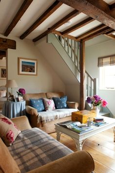 a living room filled with furniture and a staircase leading up to the second floor area