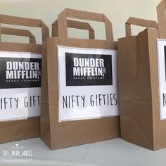 three brown paper bags with black and white labels on them, one for dunder mifflin