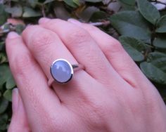 An oval-shaped cabochon Blue Chalcedony Sterling Silver Ring bezel set, a simple piece perfect for any occasion. Blue Chalcedony has an amazing soft blue hue that glows nicely when the light hits the stone. Wrapped in a Box ready for gift-giving. (r-107) Blue Chalcedony measure 11.5mm x 10mm Choose your FINISH from the drop down menu: Sterling Silver, Rose Gold Plated or 18k Vermeil Matching Stud Earring https://www.etsy.com/listing/206245486/sale-topaz-stud-blue-stone-earring?ref=shop_home_acti Modern Oval Cabochon Opal Ring As Gift, Classic Oval Blue Moonstone Ring, Adjustable Blue Moonstone Ring With Cabochon, Blue Oval Cabochon Opal Ring, Adjustable Blue Cabochon Moonstone Ring, Silver Oval Chalcedony Rings, Adjustable Blue Moonstone Cabochon Ring, Blue Oval Cabochon Natural Stone Jewelry, Blue Nickel-free Oval Cabochon Jewelry