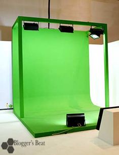 a green screen is set up in the middle of a room with white walls and flooring