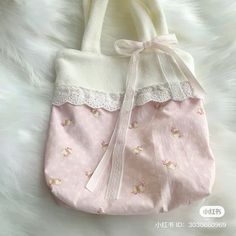 a pink and white handbag sitting on top of a furnishing covered floor