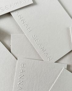 some white business cards are stacked on top of each other, with the words seaman printed on them