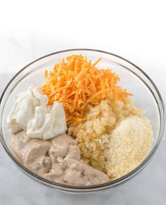 a glass bowl filled with different types of cheese and other food items on top of it